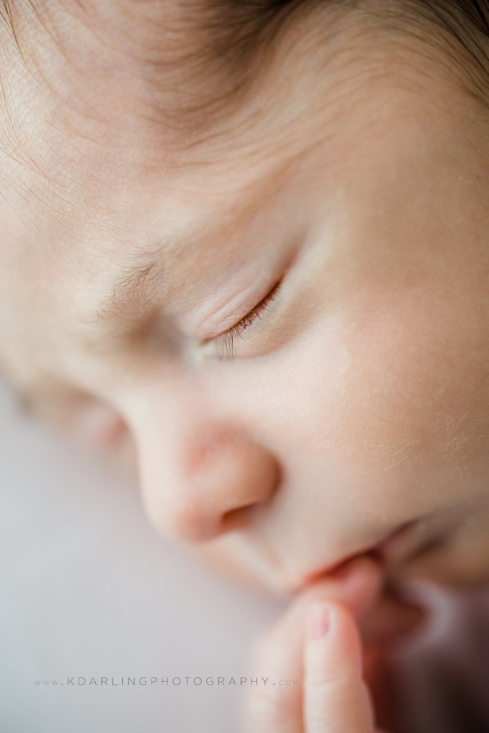 Newborn baby boy profile fingers in mouth