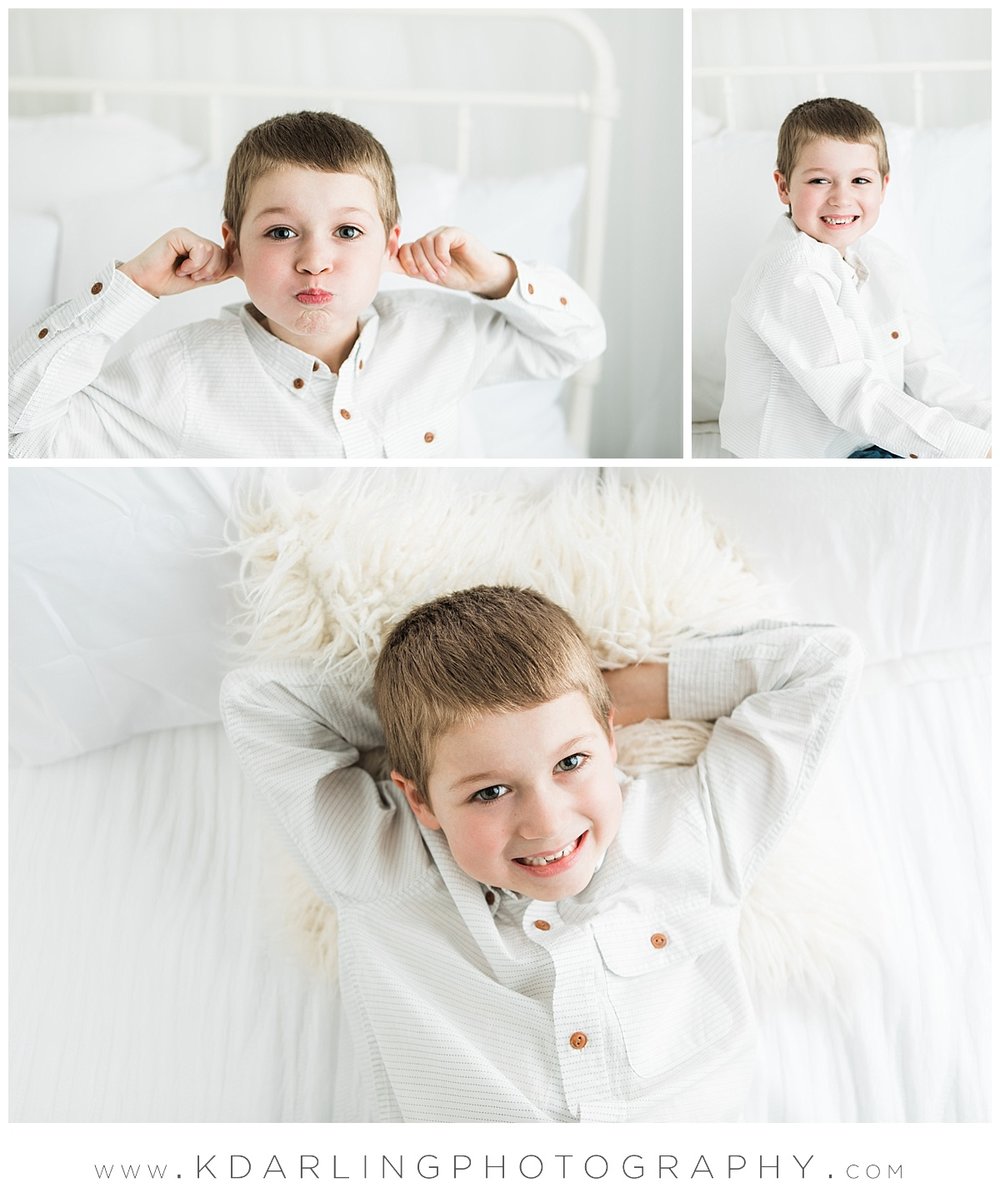 Studio session on white bed smiling six year old boy