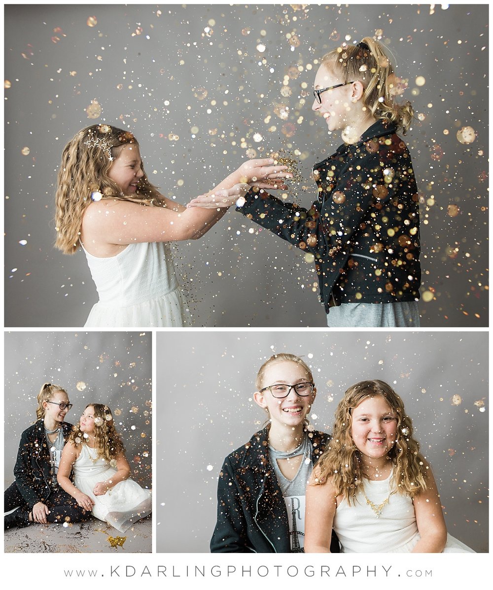 Tween sisters blowing glitter at each other