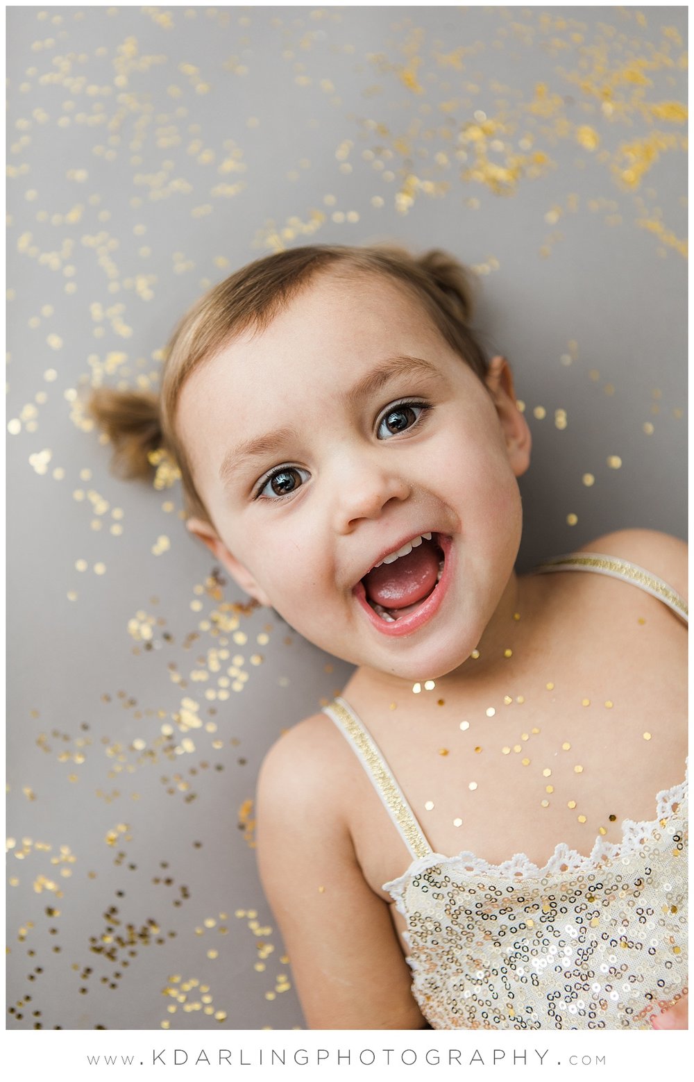 Two year old girl laying in glitter