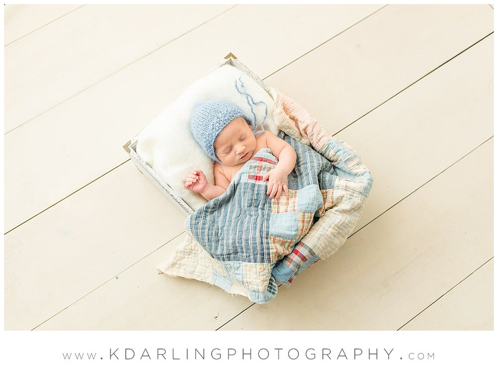 Newborn baby boy on white wood floor