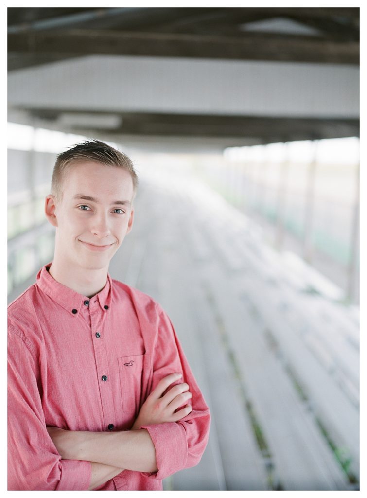 Fisher Illinois high school senior boy in pink shirt by barn