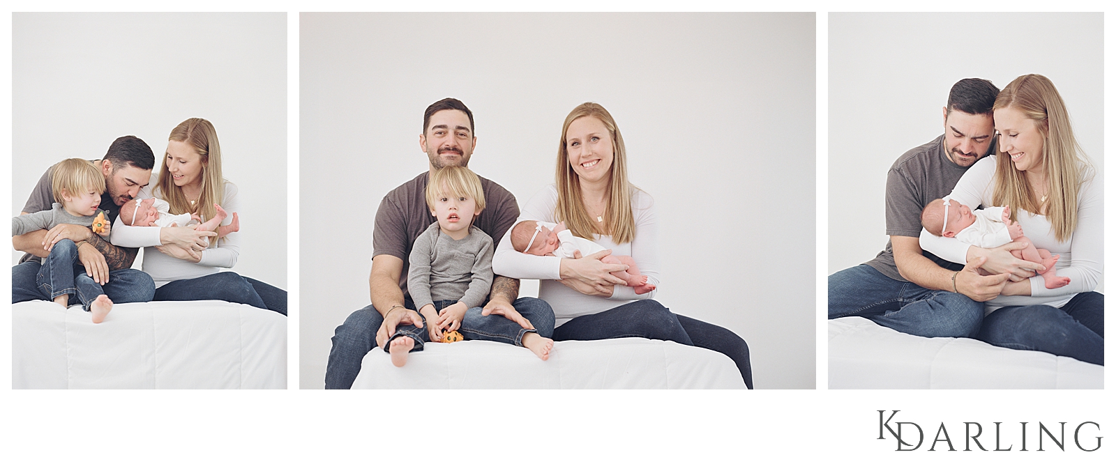 Parents and toddler sitting with newborn baby on white bed.